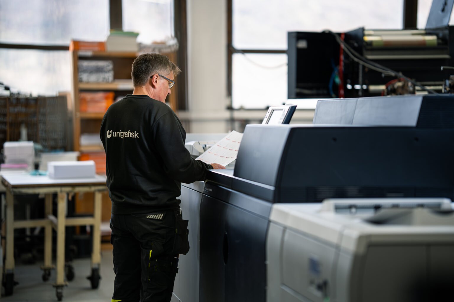 Trykker ved digitaltrykkmaskinen i produksjonslokalet